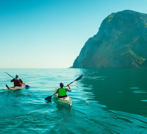 Our Mission - Kayakers on clear ocean water